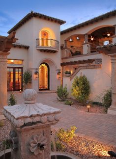 a large house with a fountain in front of it