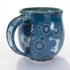 a blue and white coffee mug sitting on top of a table