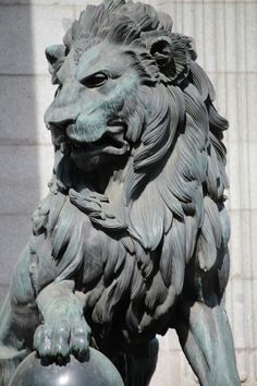 a statue of a lion holding a ball