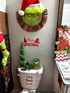 the grinch hat is hanging on the wall next to a toilet with christmas decorations