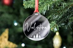 a christmas ornament hanging from a tree with the word valentine written on it