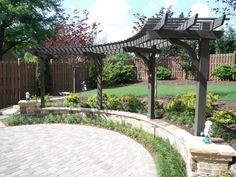 an outdoor patio area with brick pavers and pergolated trellis on the side