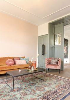 a living room with two couches, a coffee table and a rug on the floor