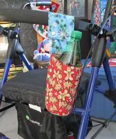 a blue walker with various items on it and a bag in the back pocket, sitting next to a pile of other items