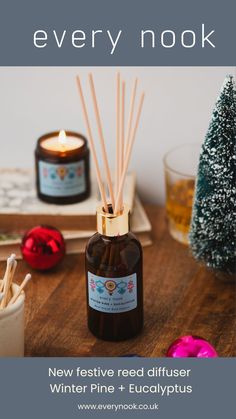 a bottle of reed diffuser sitting on top of a wooden table next to a candle