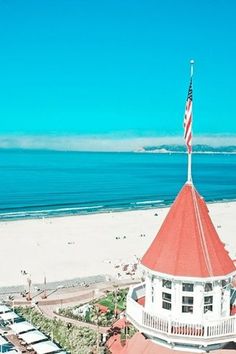 an aerial view of the beach and ocean in santa cruz, california with a flag on top