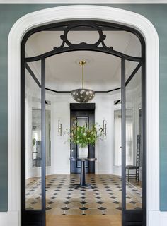 an entry way with black and white checkered flooring, potted plant in the center