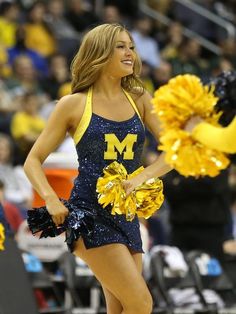 a woman in a cheerleader uniform holding a pom - pom