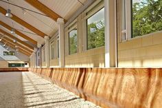 the inside of a building with large windows and wood paneling on the outside wall