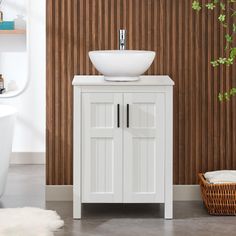 a white sink sitting next to a wooden wall