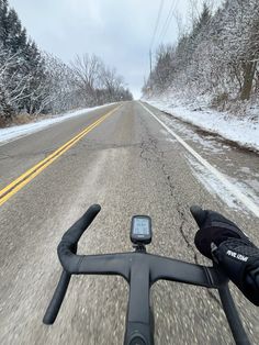 a person riding a bike down a snow covered road