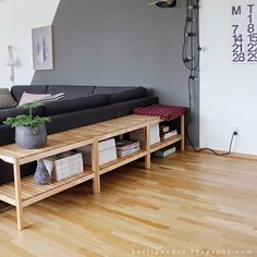 a living room filled with furniture and a plant on top of a wooden coffee table