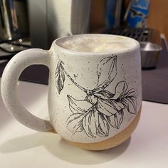 a white coffee mug sitting on top of a counter