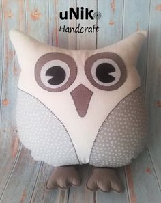 an owl pillow sitting on top of a wooden chair with the words, unik handcraft