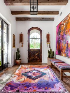 the entryway is decorated with colorful rugs and artwork