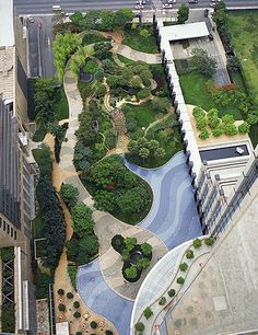 an aerial view of a city with lots of trees and plants on the sides of buildings