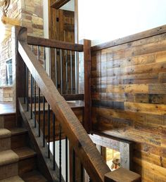 a wooden stair case next to a brick wall