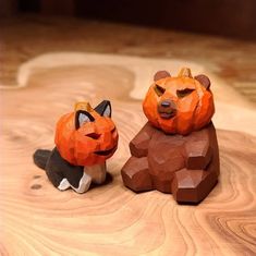 two carved pumpkins sitting next to each other on top of a wooden table,