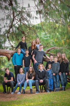 a large group of people standing in front of a tree