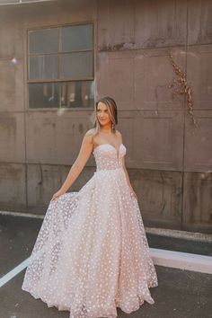 a woman in a wedding dress poses for the camera