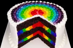 a rainbow cake with white frosting and layers