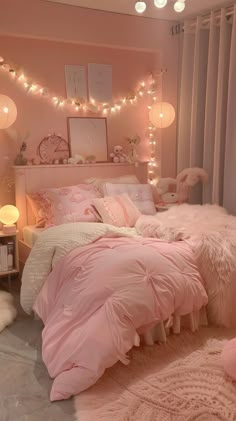 a bedroom decorated in pink and white with lights