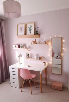 a bedroom with pink furniture and lights on the wall, along with a white desk