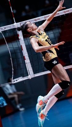 a female volleyball player jumping up to hit the ball