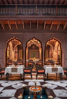 an indoor dining area with tables, chairs and chandeliers in the middle of it