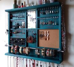 a blue wall mounted jewelry organizer with lots of necklaces