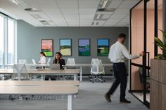 an office with people sitting at desks and working on laptops in the background