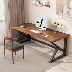 a wooden desk with a laptop on top of it next to a chair and potted plant