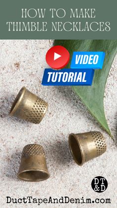 three brass bells sitting on top of sand next to a green leaf with the words how to make thimble necklaces