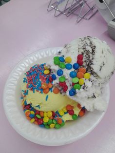 two scoops of ice cream with sprinkles and colored candies on top