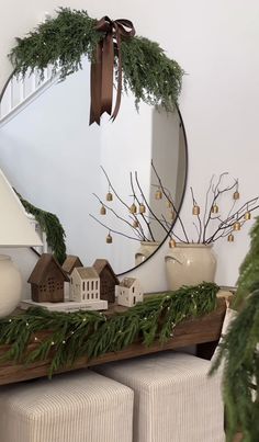 a mirror sitting on top of a wooden table next to a planter filled with greenery