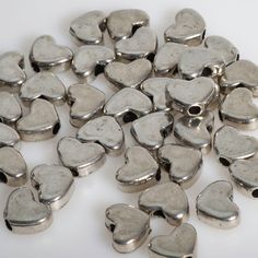 a pile of metal hearts sitting on top of a white table