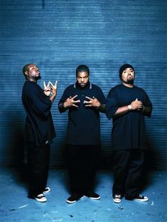 three men standing next to each other in front of a blue wall with the words westside connection written on it