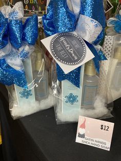 two bottles of body lotion sitting next to each other with blue bows on them