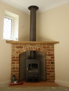 two pictures of a fireplace in a living room, one with a wood burning stove