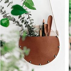 a hanging planter with pens and pencils in it