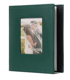 a green leather photo album with a bride and groom kissing