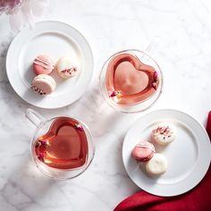 three heart shaped desserts on plates next to each other