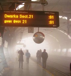 people are standing in the fog at a train station as it's time is 11 00