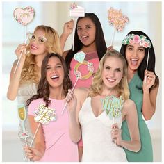 a group of women holding up cake toppers and lollipops in front of them