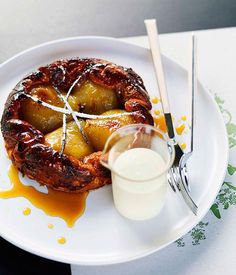 a white plate topped with fruit covered in syrup