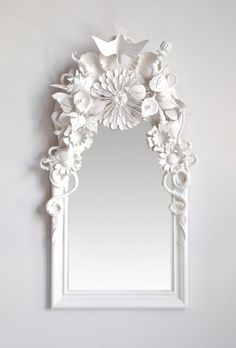 a white mirror sitting on top of a wall