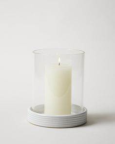 a white candle in a glass container