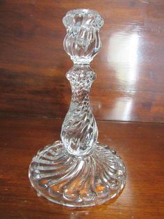 a glass candle holder sitting on top of a wooden table