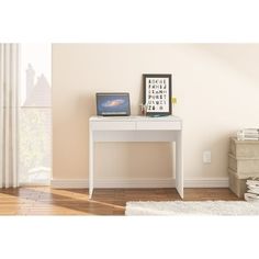 a laptop computer sitting on top of a white desk next to a stack of books