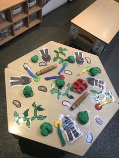 the table is covered with paper cutouts and scissors, plants, and other things